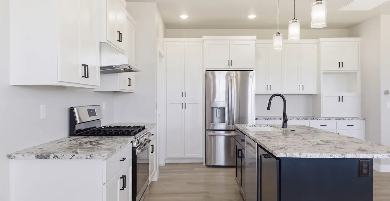 Westview Ridge kitchen: white shaker cabinets, granite counters, navy island, matte-black faucet and stainless appliances